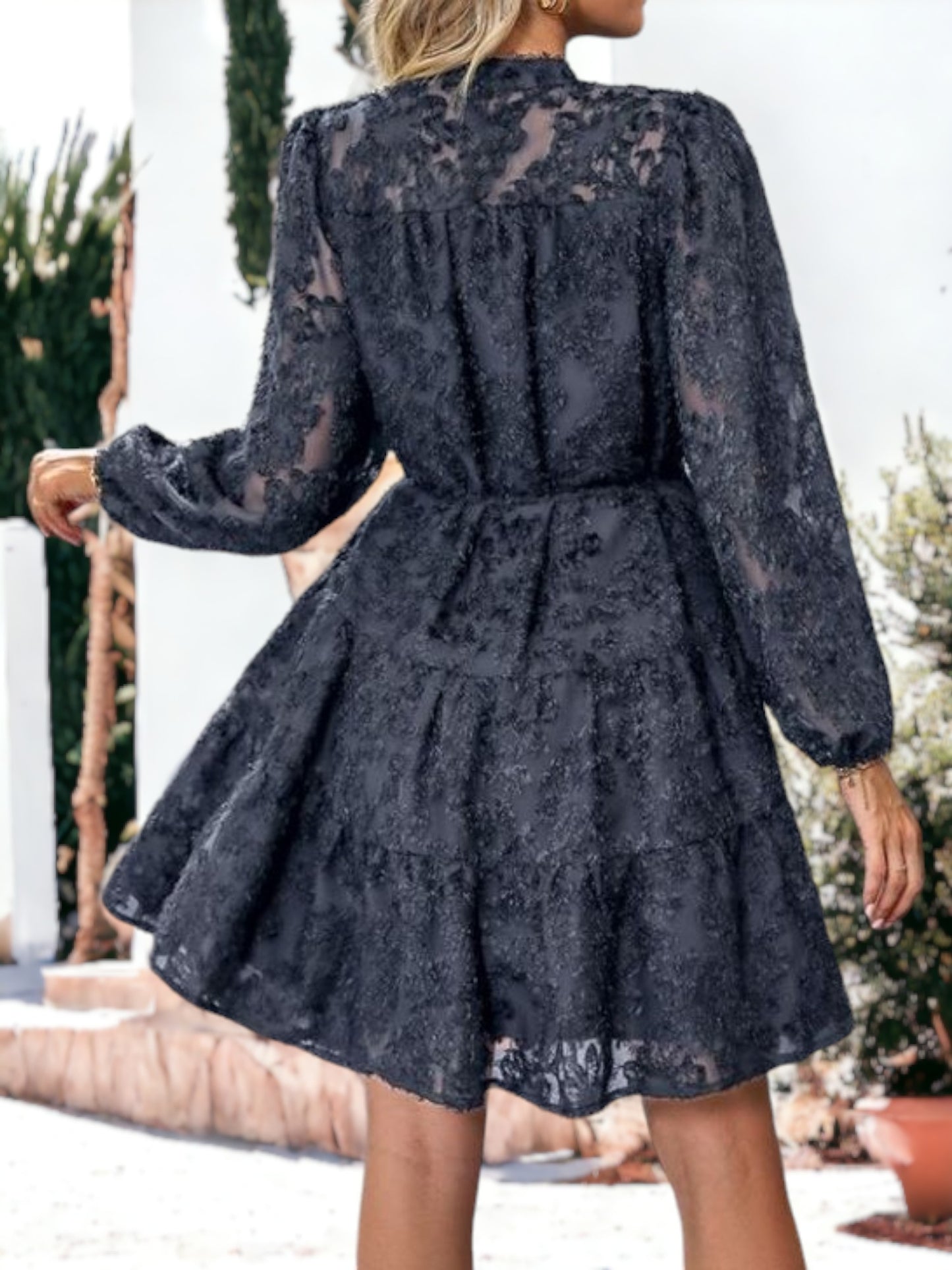 Vestido corto con volantes, cintura anudada, mangas largas y detalles de encaje texturizado