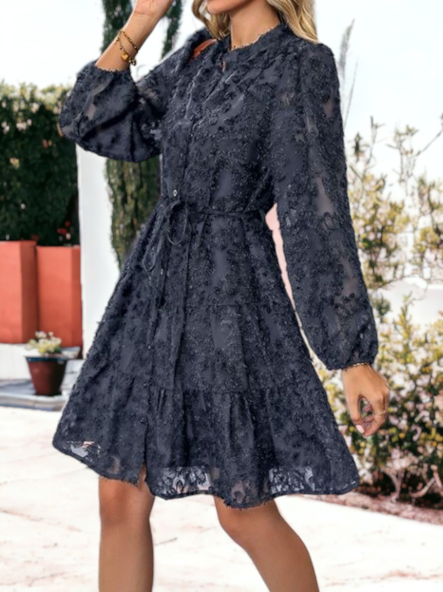 Vestido corto con volantes, cintura anudada, mangas largas y detalles de encaje texturizado