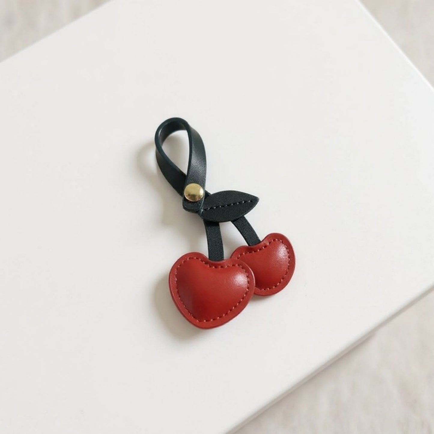 Anna-Kaci Faux Leather Cherry Heart Keychain with Black Leaf Strap and Gold Rivet Detail