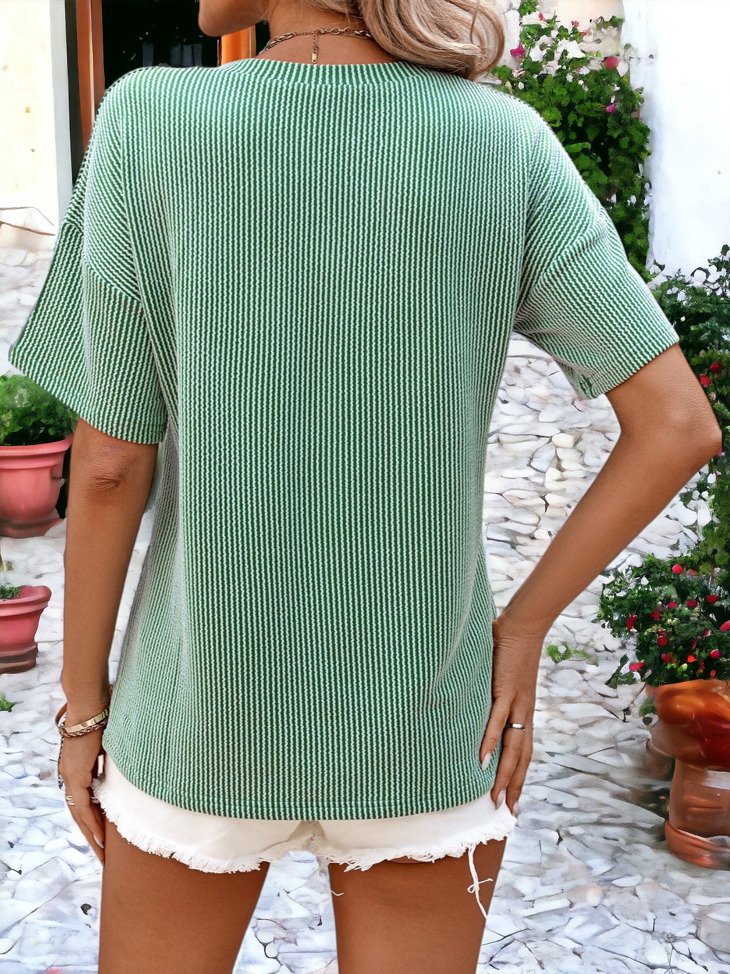 Camiseta holgada con cuello redondo, textura de rayas y bolsillos laterales detallados