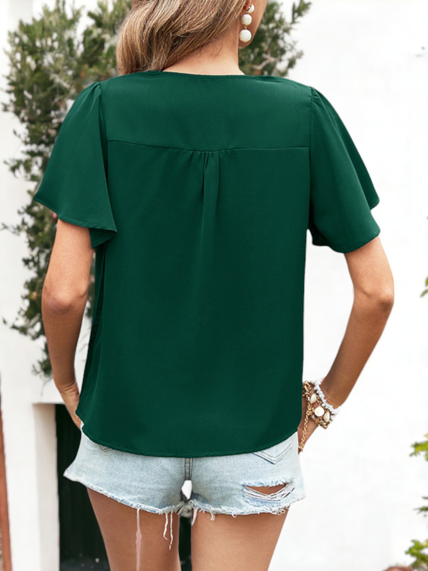 Blusa plisada con escote en V y botones con detalles y mangas con volantes