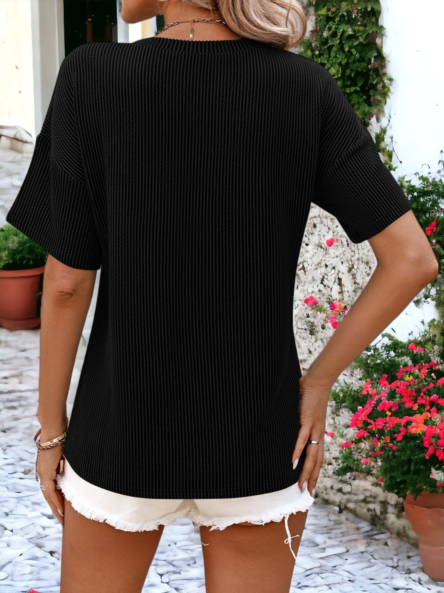 Camiseta holgada con cuello redondo, textura de rayas y bolsillos laterales detallados