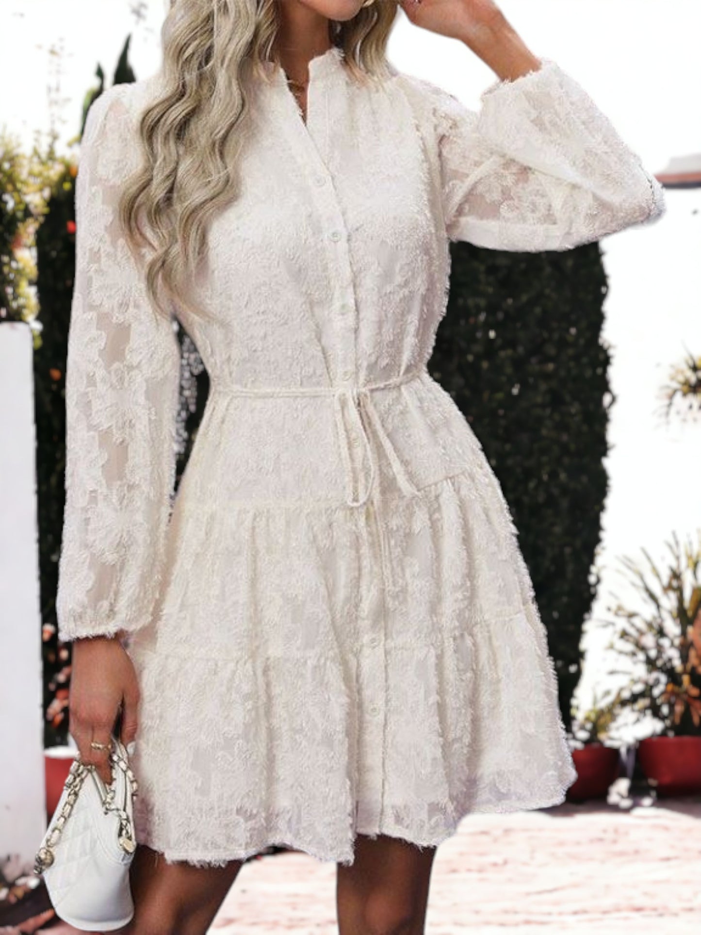 Vestido corto con volantes, cintura anudada, mangas largas y detalles de encaje texturizado