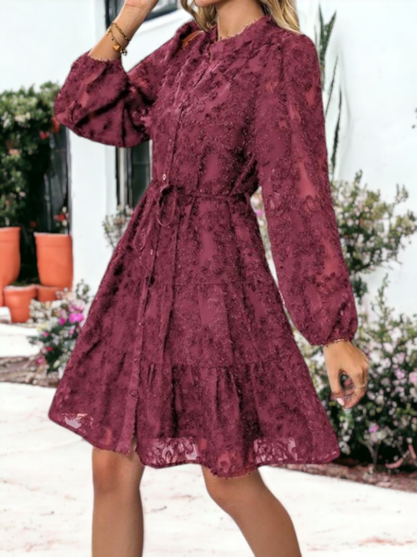 Vestido corto con volantes, cintura anudada, mangas largas y detalles de encaje texturizado