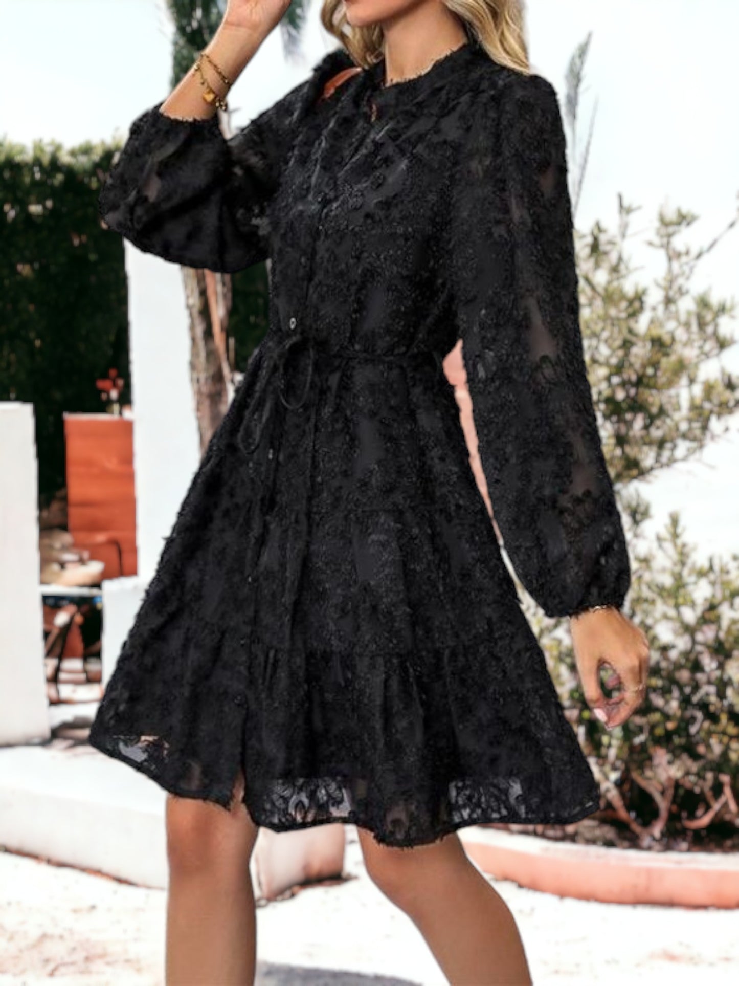 Vestido corto con volantes, cintura anudada, mangas largas y detalles de encaje texturizado