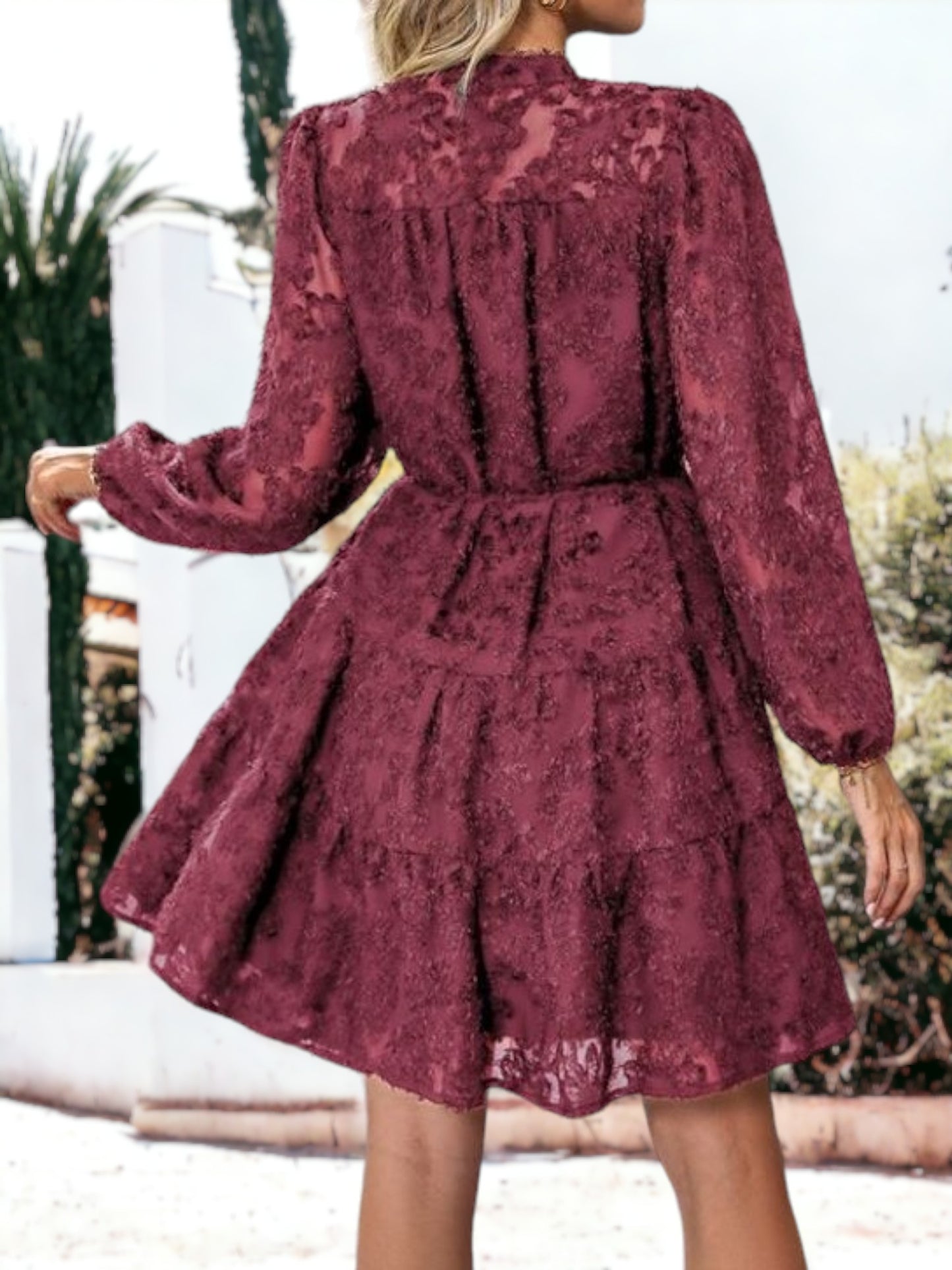 Vestido corto con volantes, cintura anudada, mangas largas y detalles de encaje texturizado