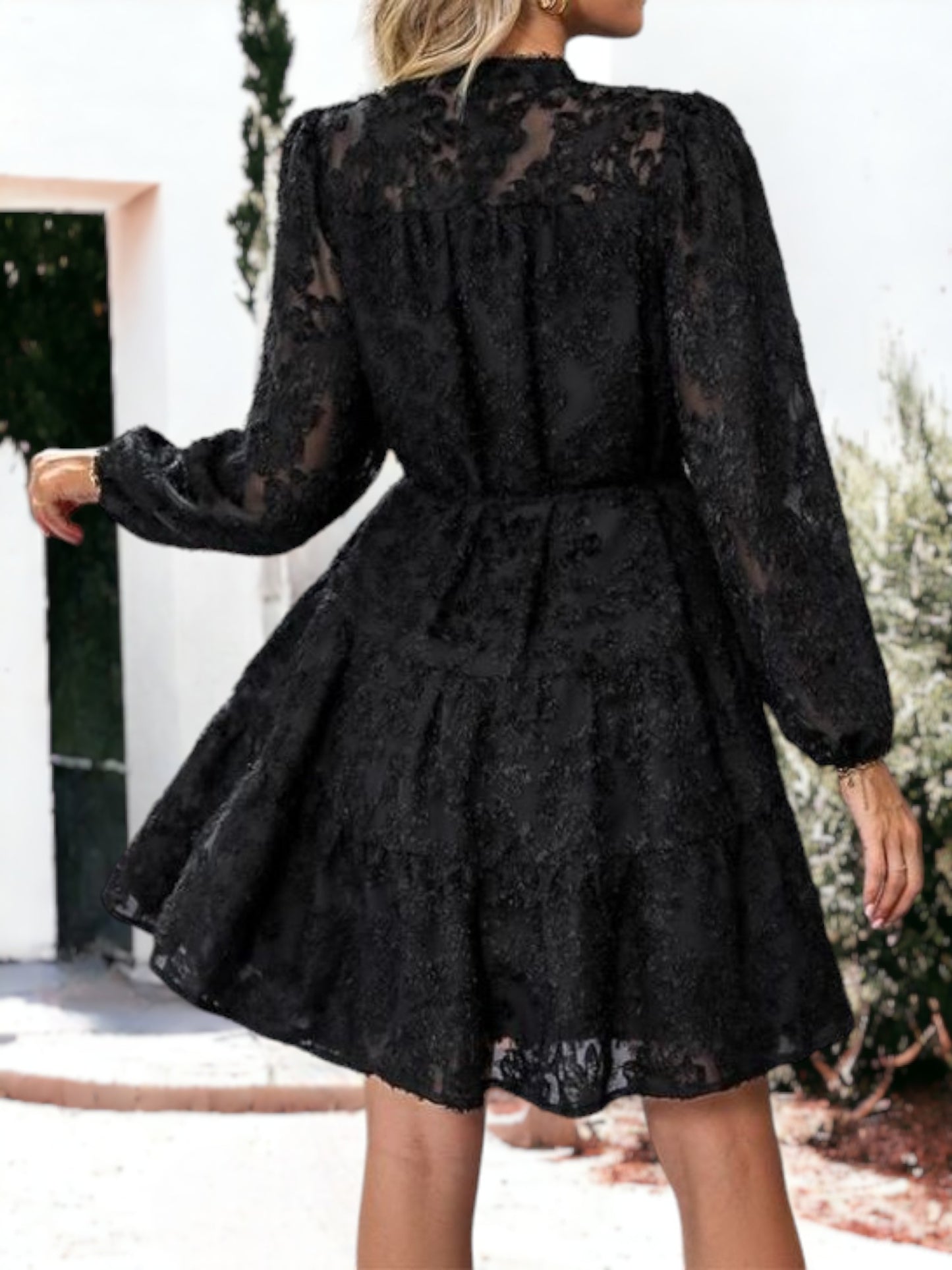 Vestido corto con volantes, cintura anudada, mangas largas y detalles de encaje texturizado