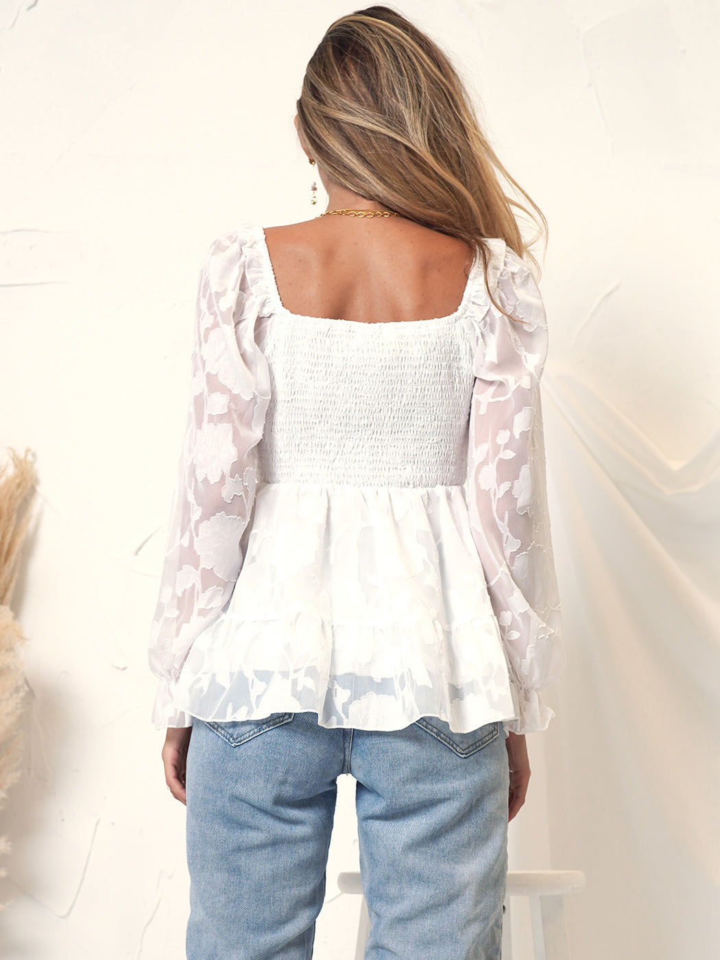Blusa peplum con detalle floral fruncido