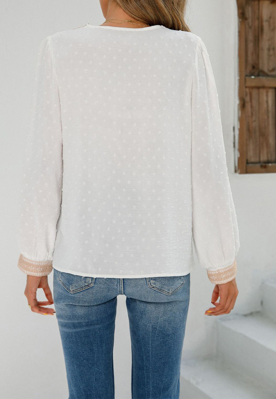 Blusa de lunares con pinza para el cuello y borlas