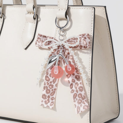 Anna-Kaci Leopard Print Ribbon Keychain with Pearl Bow and Cherry Charms