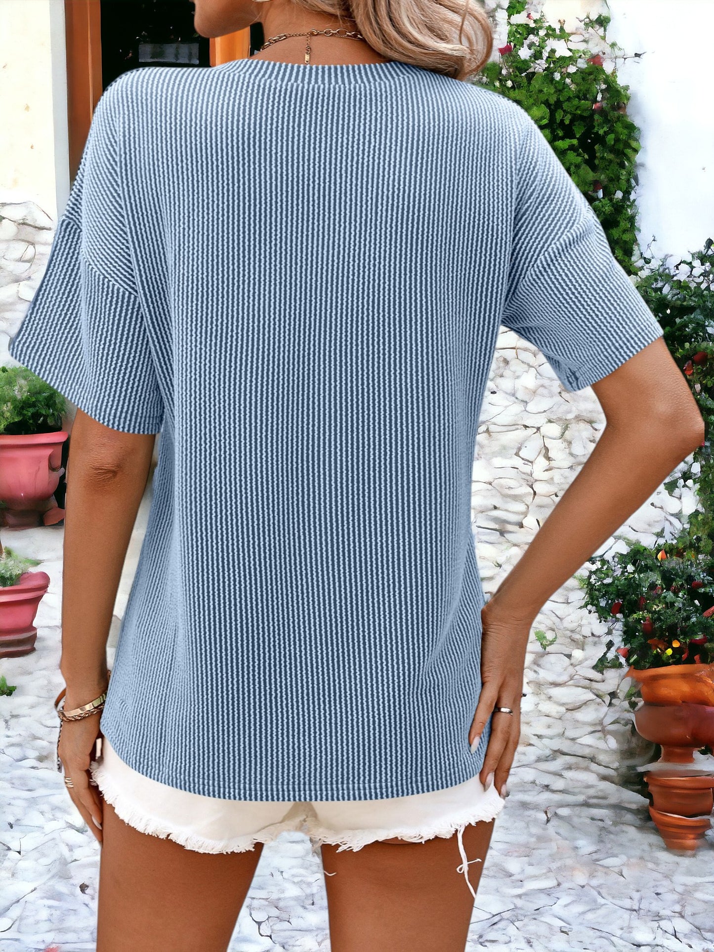 Camiseta holgada con cuello redondo, textura de rayas y bolsillos laterales detallados