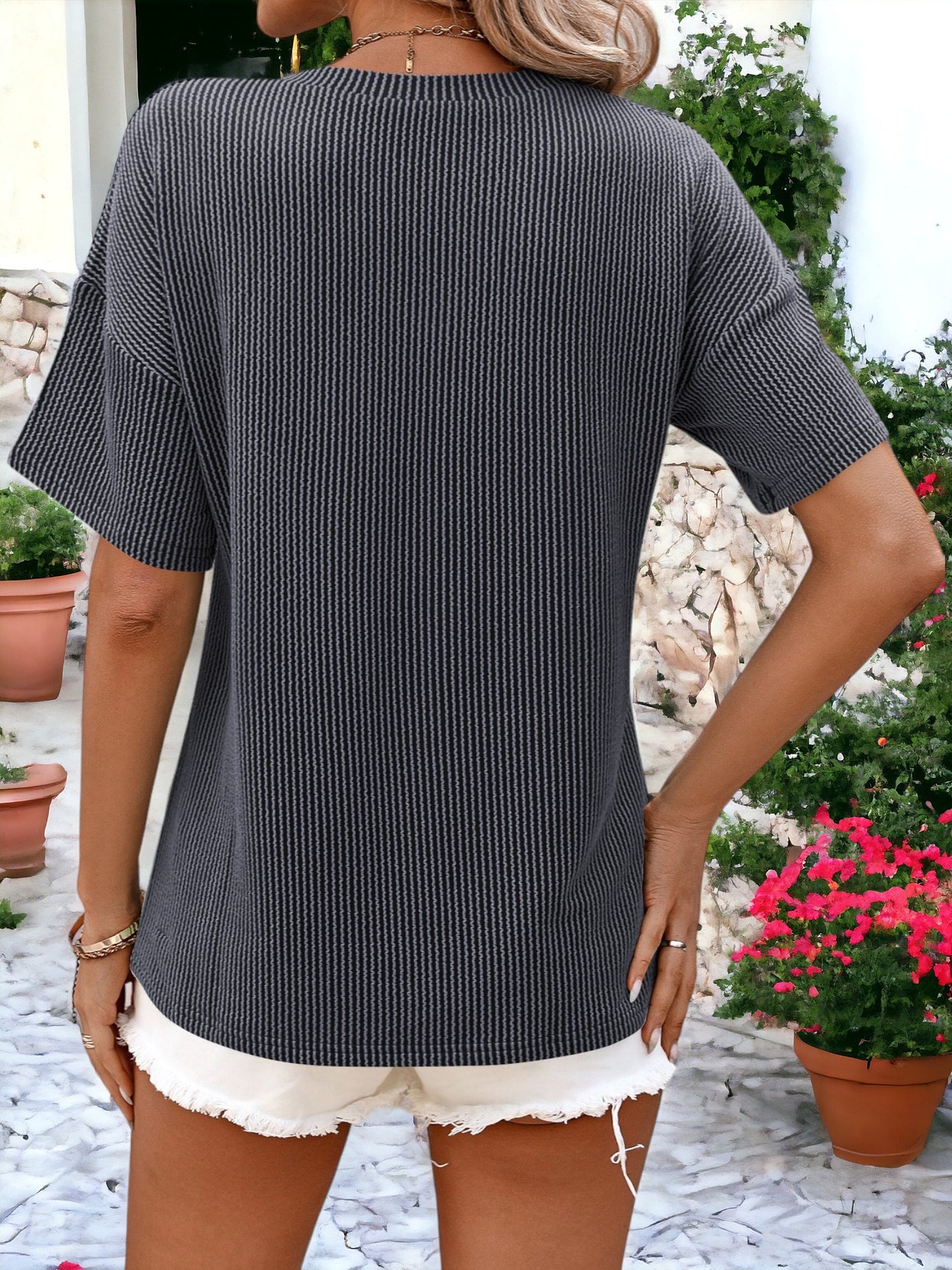 Camiseta holgada con cuello redondo, textura de rayas y bolsillos laterales detallados