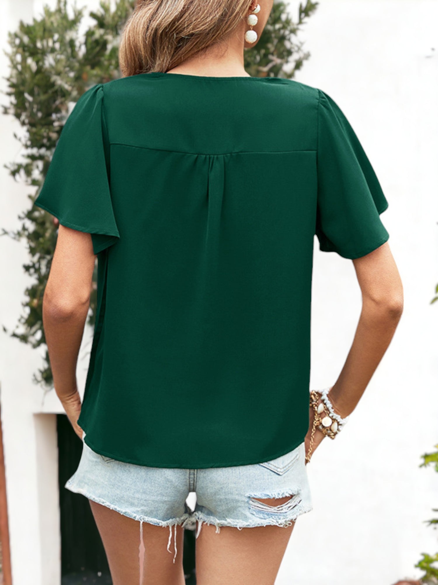 Blusa plisada con escote en V y botones con detalles y mangas con volantes