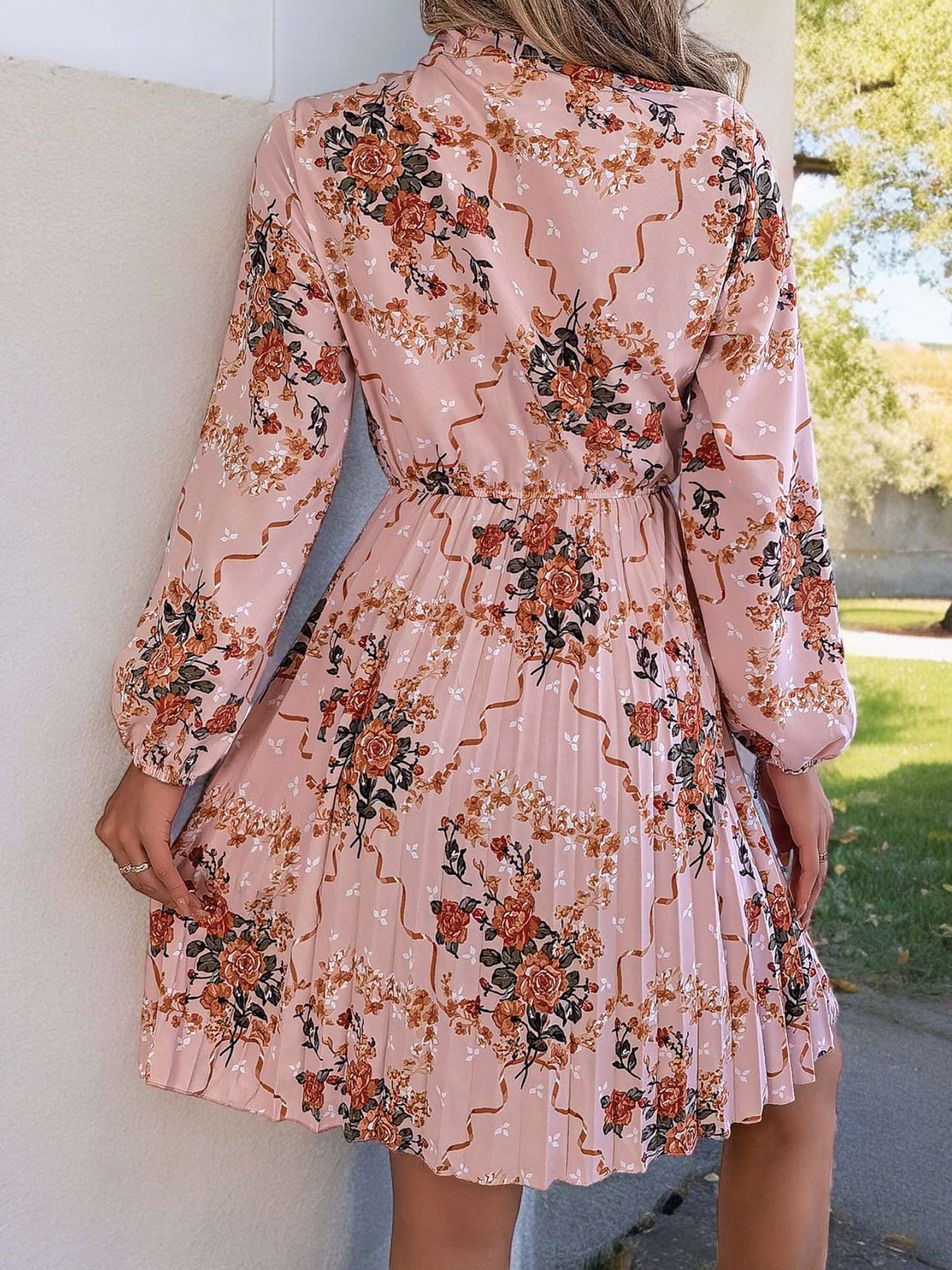 Vestido con estampado floral de manga larga, cuello con lazo y falda plisada