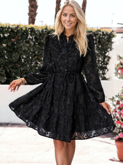 Vestido corto con volantes, cintura anudada, mangas largas y detalles de encaje texturizado