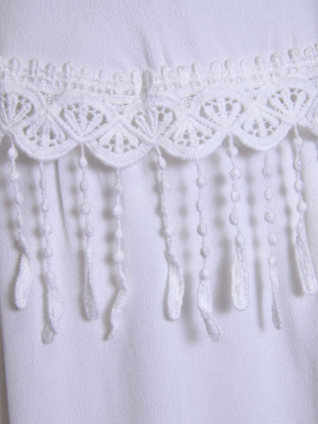 Vestido de novia tejido con ribete de flecos y estilo Cluny inspirado en los años 50