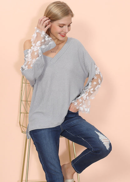Suéter con mangas de obispo y apliques de flores 